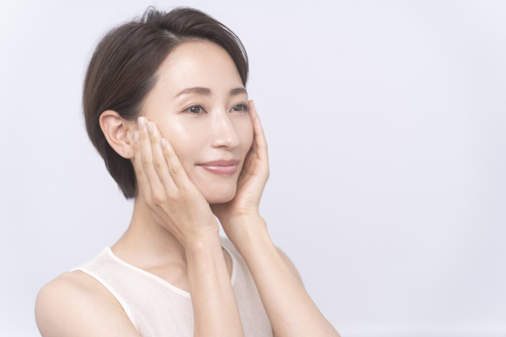 Beauty portrait of middle aged asian woman Skin care. An asian woman with beauty face is touching healthy facial skin.